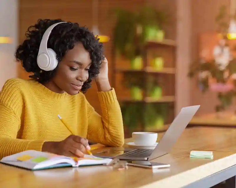 Élève Talia suivant un cours en ligne, au casque audio